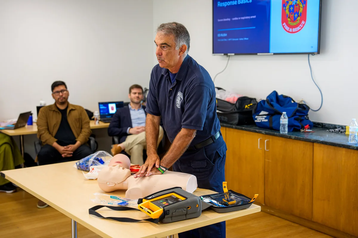 An instructor demonstrating CPR to Care Specialists during training